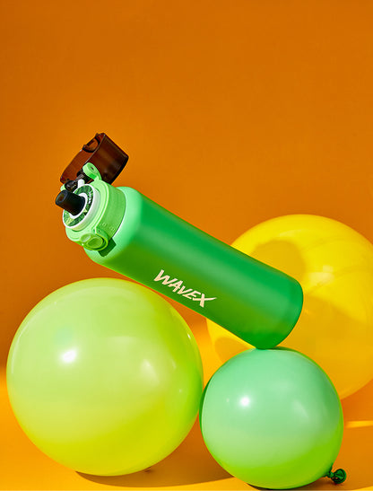 A green and yellow balloon and water bottle, both showcasing a honey peach flavor, create a cheerful and colorful display